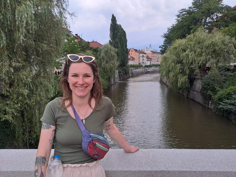 A lady standing in front of a canal.