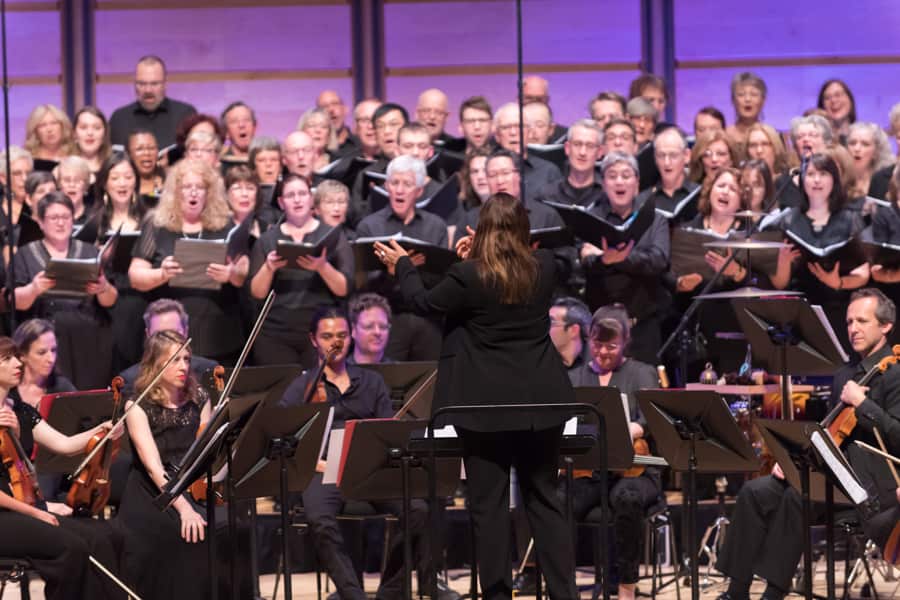 A photo of the Leichhardt Espresso Chorus performing on stage with an orchestra.