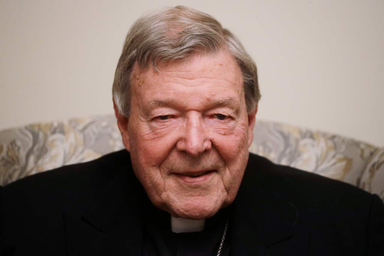 Close up of George Pell wearing black and sitting in a chair.