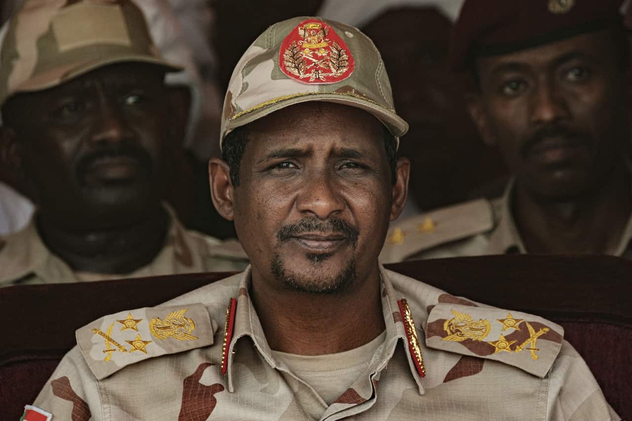 Army officer wearing a hat looks at camera.