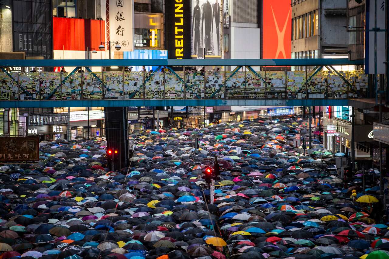Protesters are seen holding up umbrellas while they walk down a street in Hong Kong in August 2019.