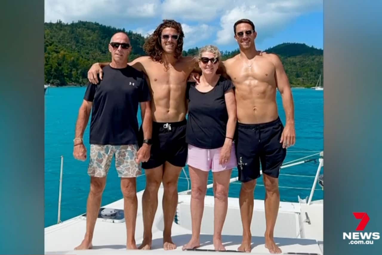 Jake and Callum Robinson and their parents on a boat in the ocean.