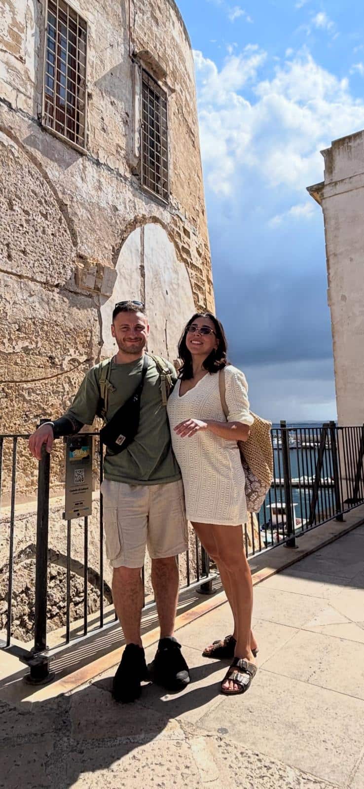 A man and woman stand in front of a historic building.