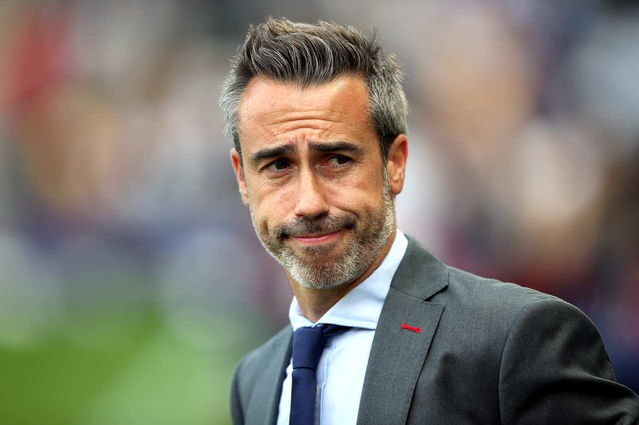 A man in a suit and tie looks sideways.