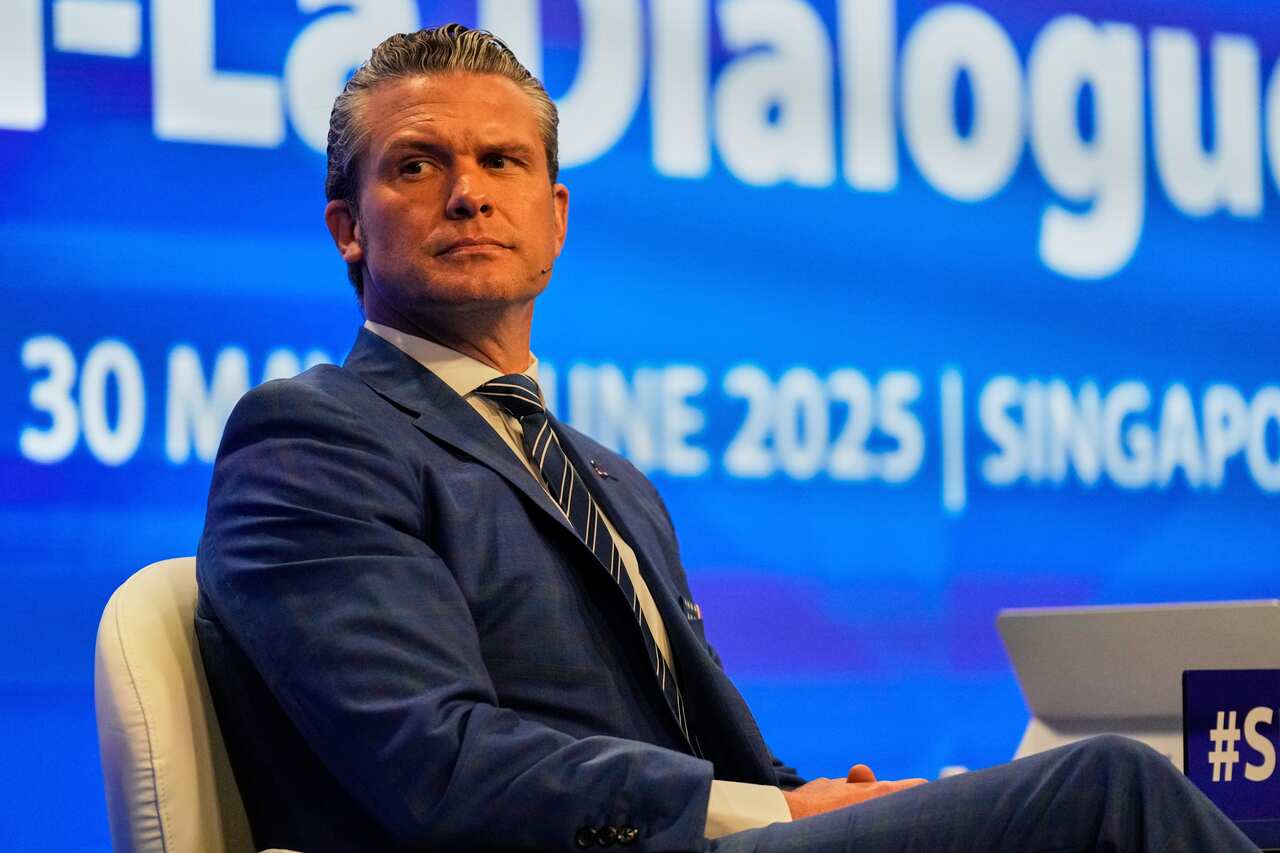 A man in a suit sitting at a conference seat