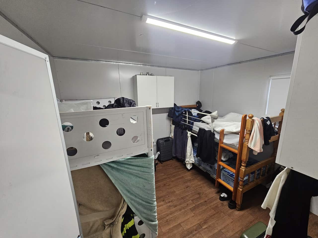 A photo of the inside of a small caravan, fitted with two bunk beds.