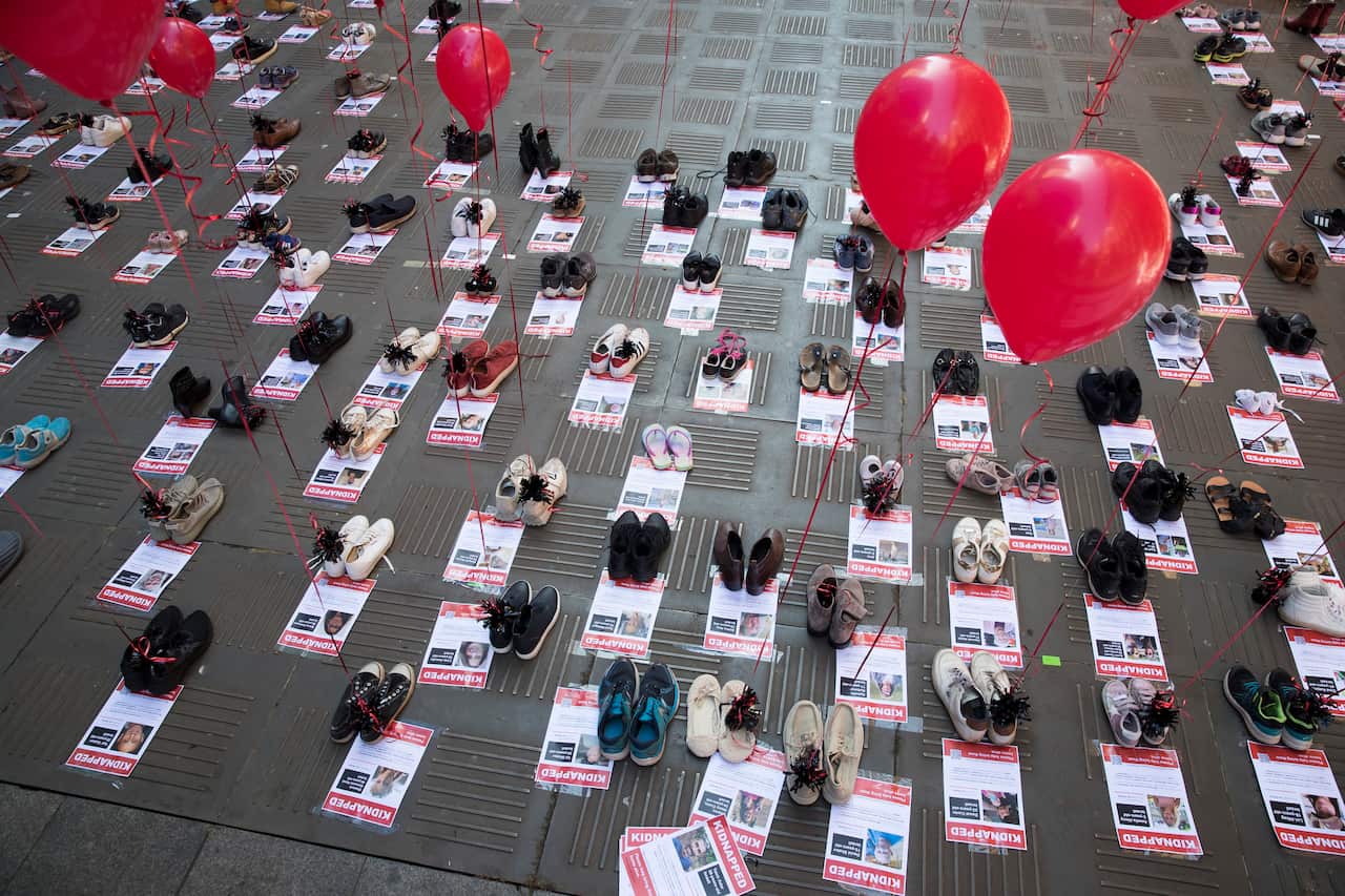Empty pairs of shoes next to posters that say 'Kidnapped'