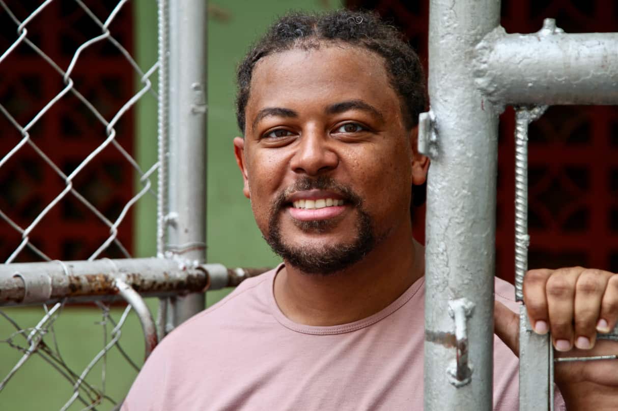 Close-up shot of a man wearing a pink shirt.