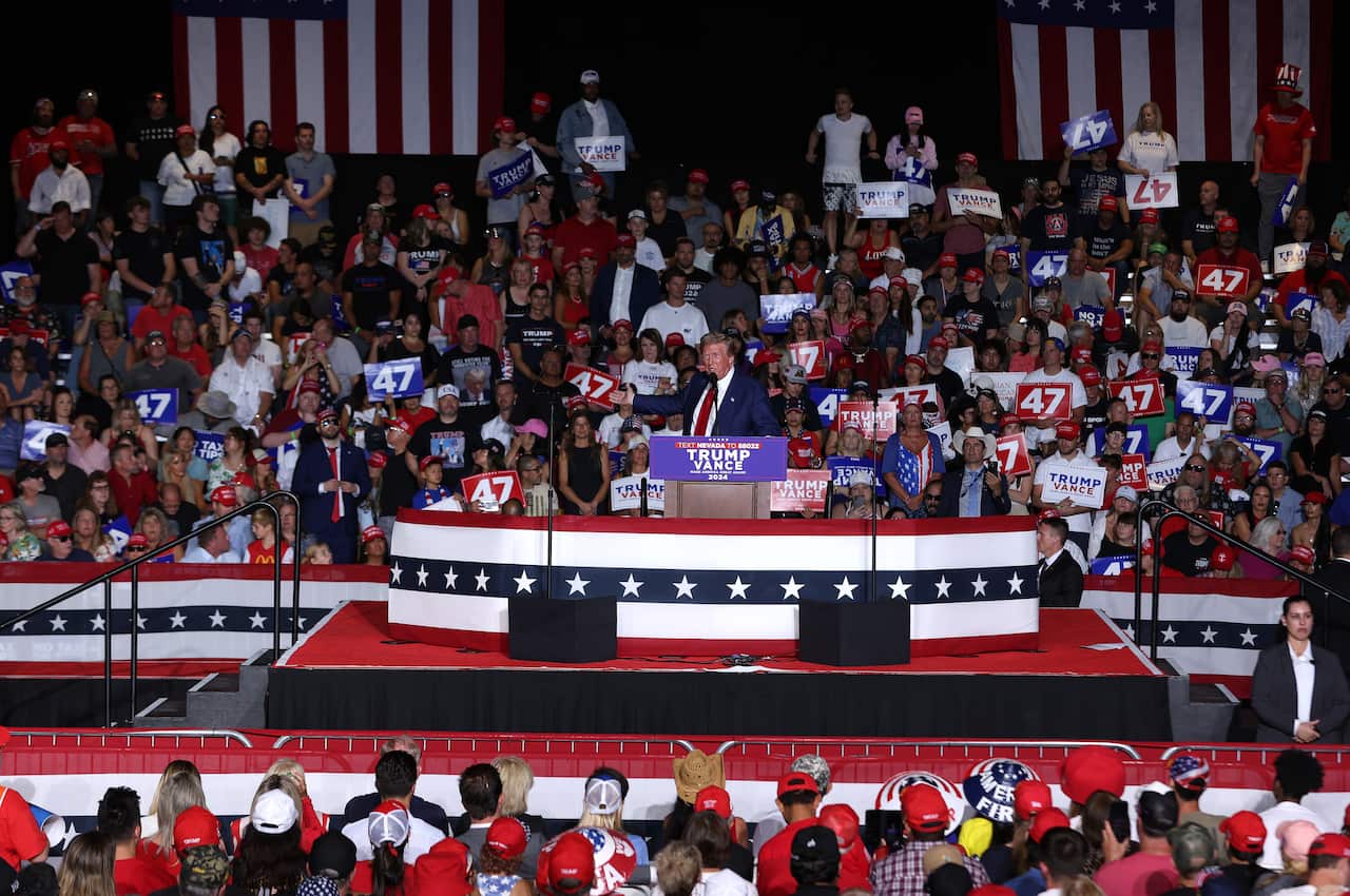 A man stands on a stage in front of a crowd.