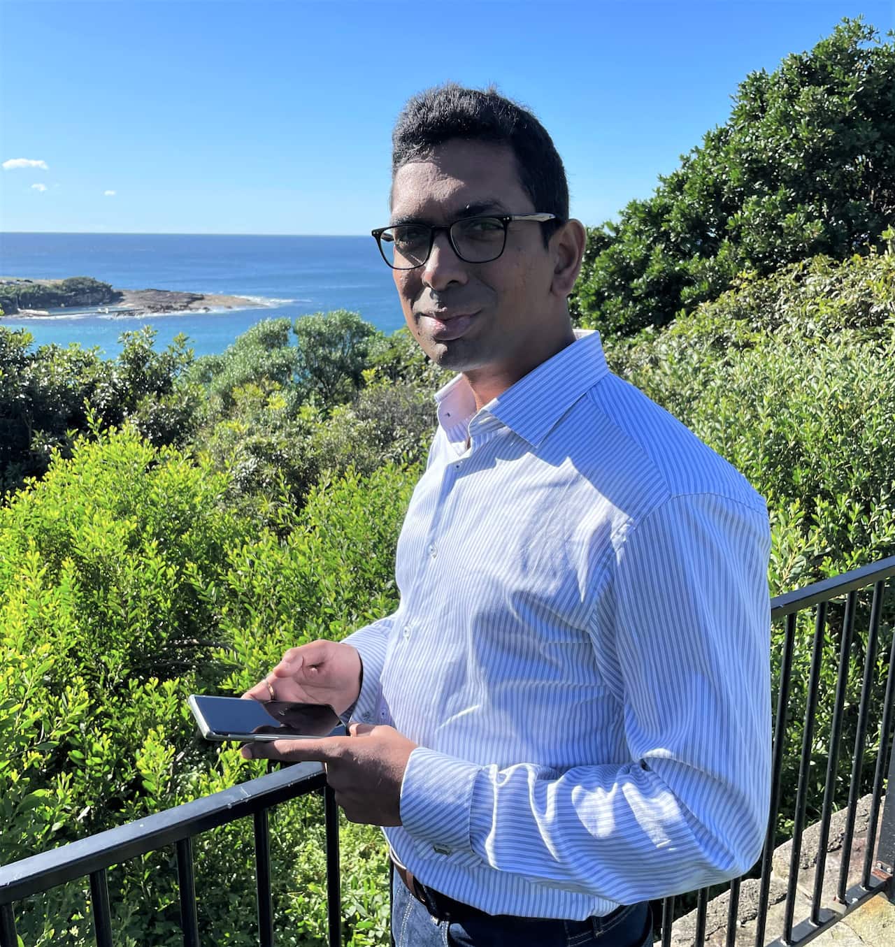 Rakesh Routhu standing at a beachside park in Sydney 