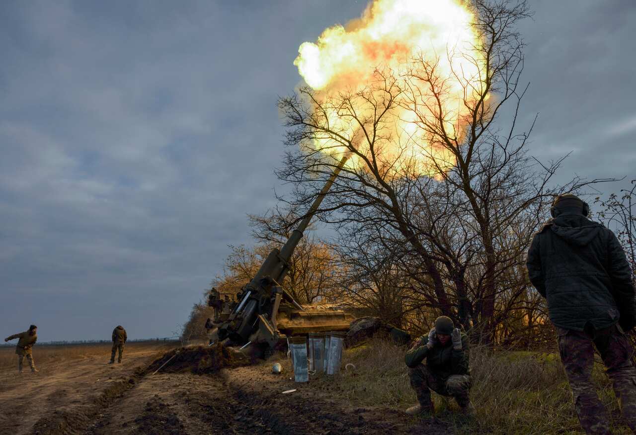 Ukrainian servicemen shooting a cannon.