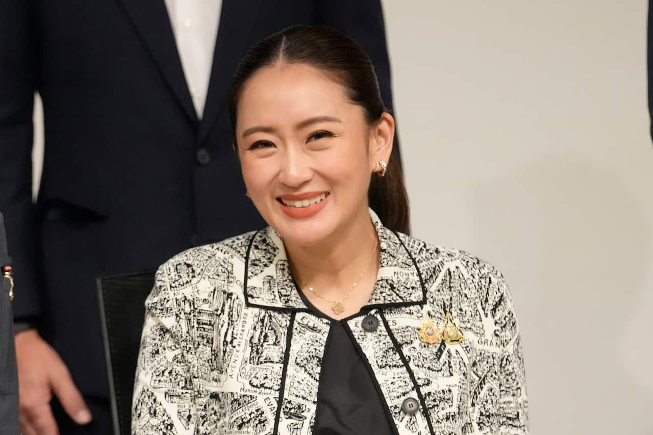 A woman wearing a black and white top smiles