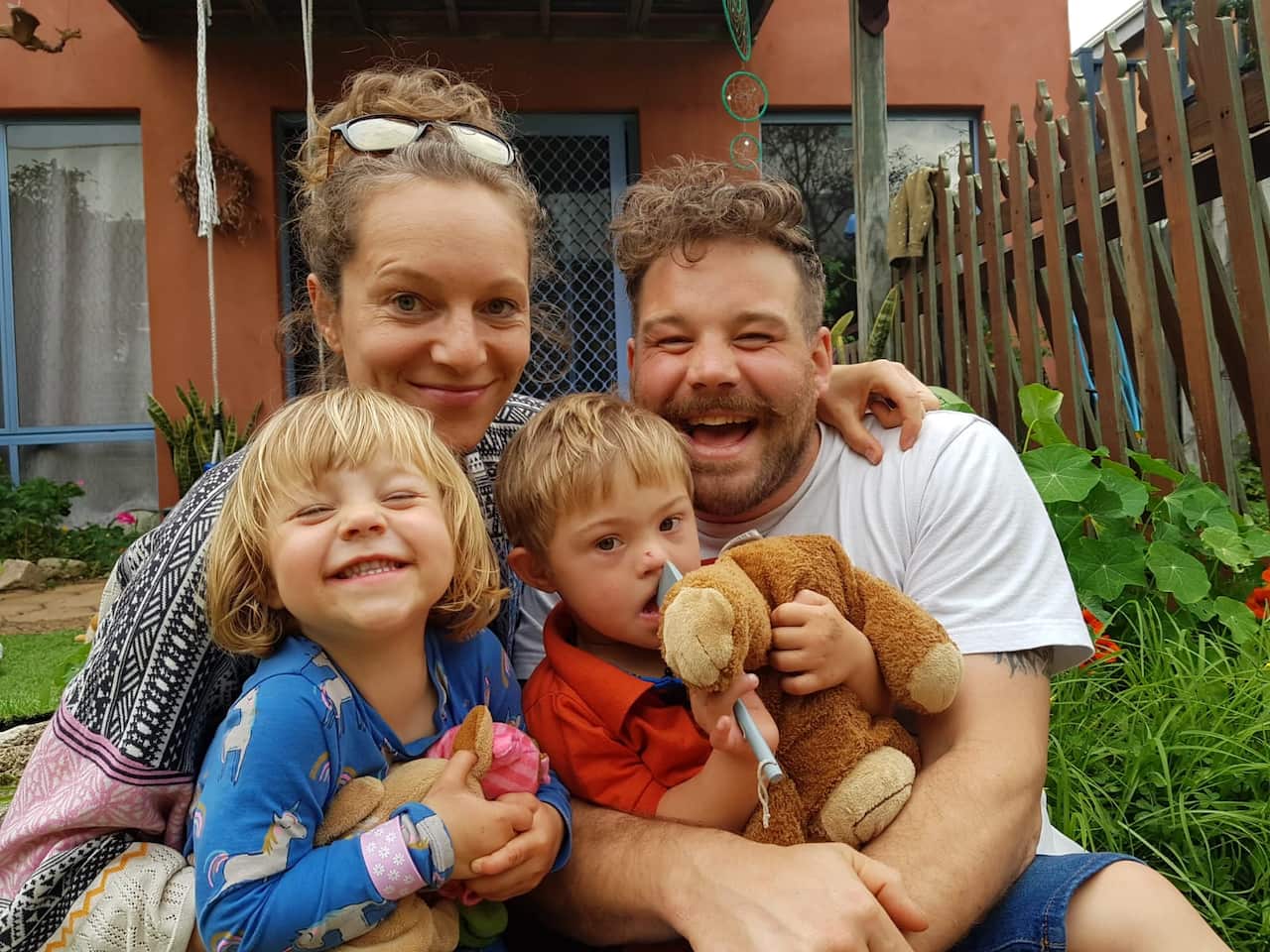 Parents with their two children smile into the camera