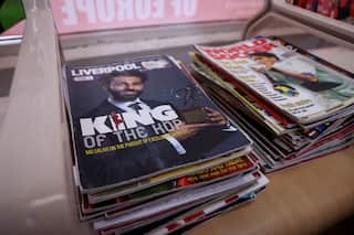 Stacks of football magazines, featuring Liverpool star Mohamed Salah on the cover, sit waiting for customers inside Kleames Dawod's Chatswood barber shop ahead of the Socceroos' World Cup match against Egypt.