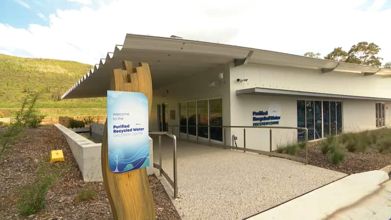 The exterior of a modern building has signage reading "Welcome to the Purified Recycled Water Discovery Centre".