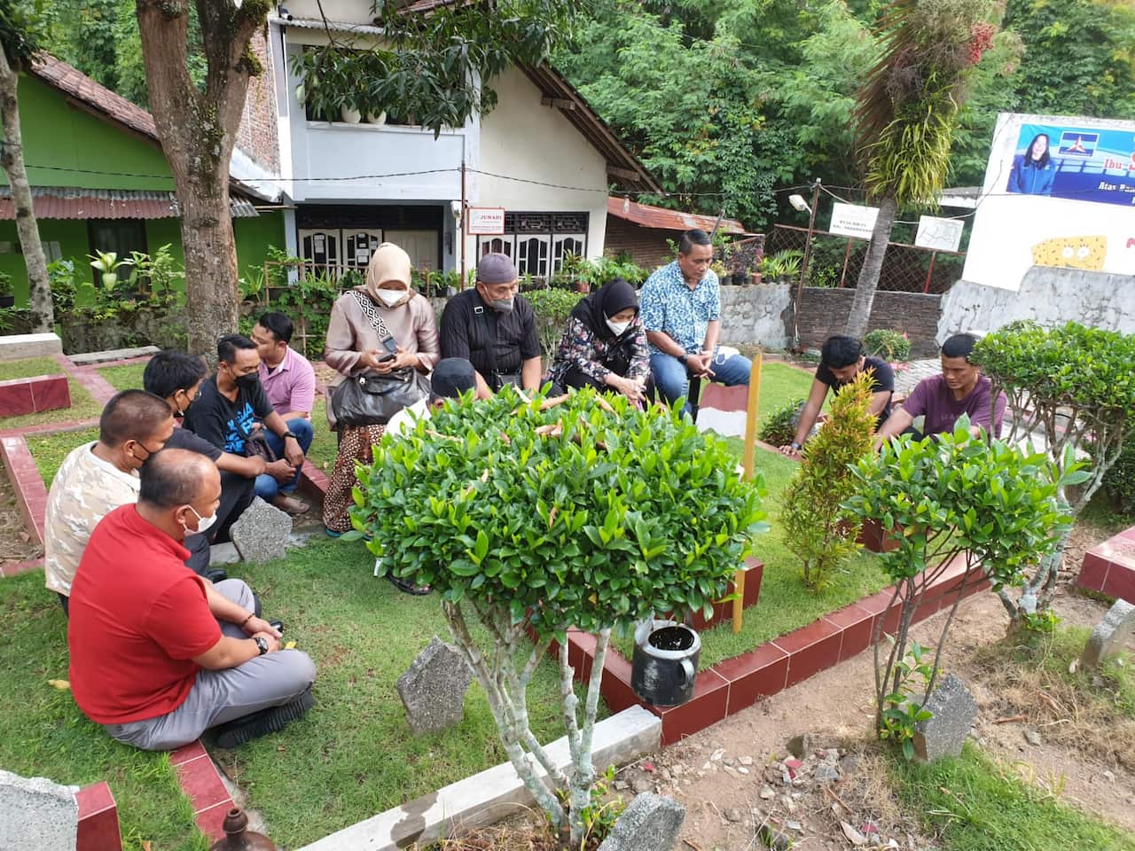 Sebuah keluarga sedang berziarah ke makam keluarga mereka yang telah wafat.