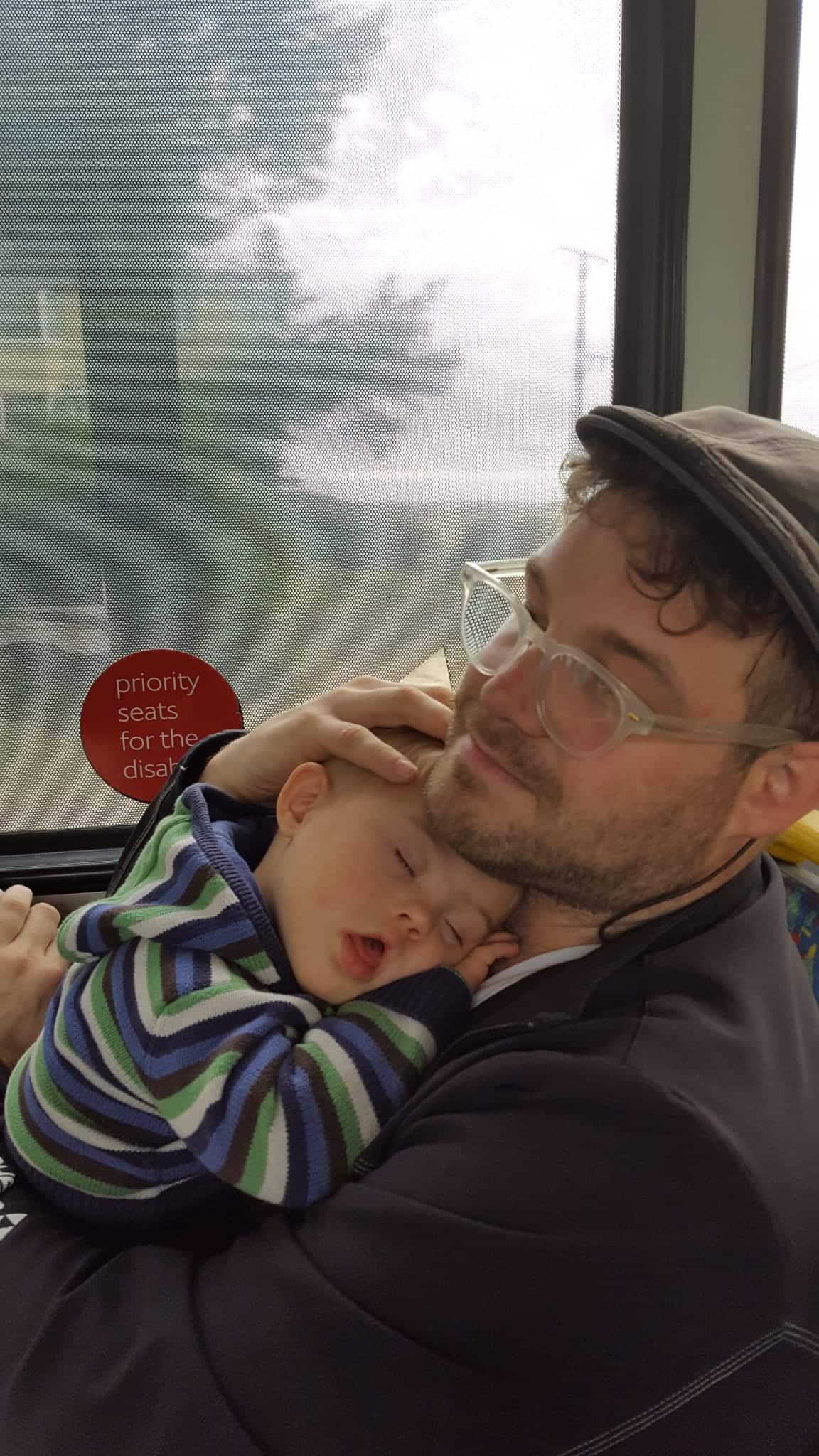 A man cradles a baby on a train