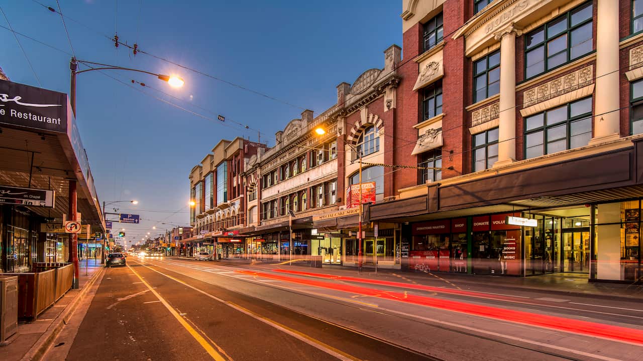 A street at dusk, with shops lining either side.