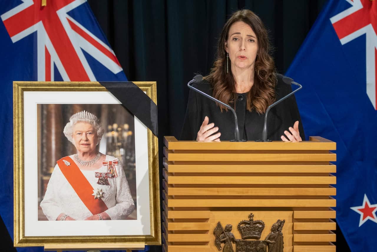 Jacinda Ardern speaks near a portrait of the Queen
