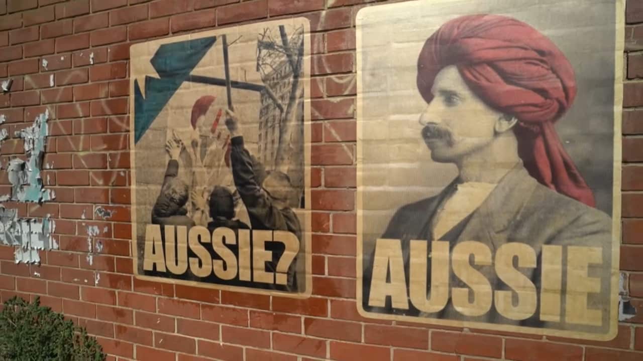 Two posters, one showing protesters tearing down a poster with the caption "AUSSIE?" and another showing a man wearing a turban with the caption "AUSSIE"