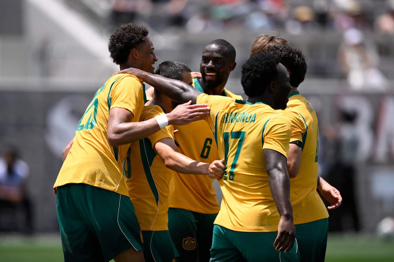 Football players in golden jerseys celebrating after a goal