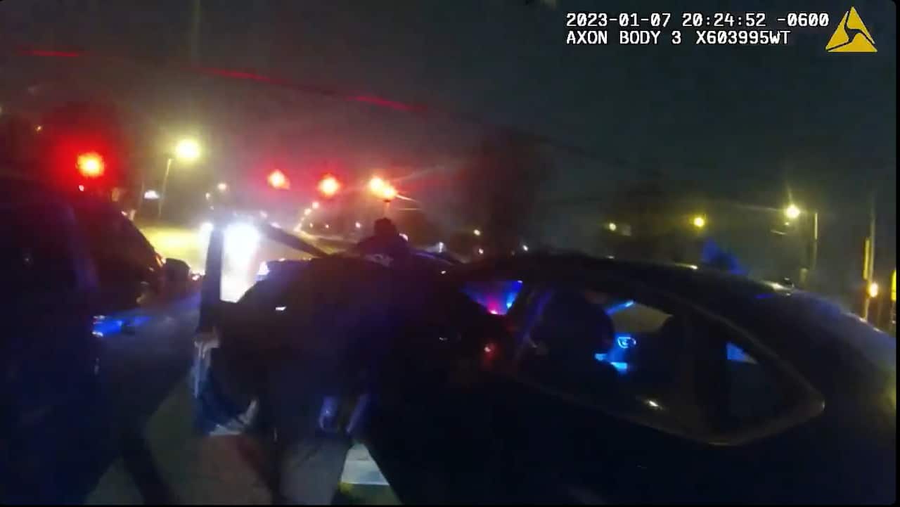 Police pulling a man out of a car. 