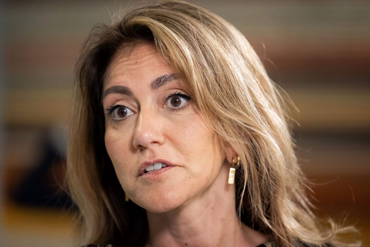 A woman with light brown hair looking serious.