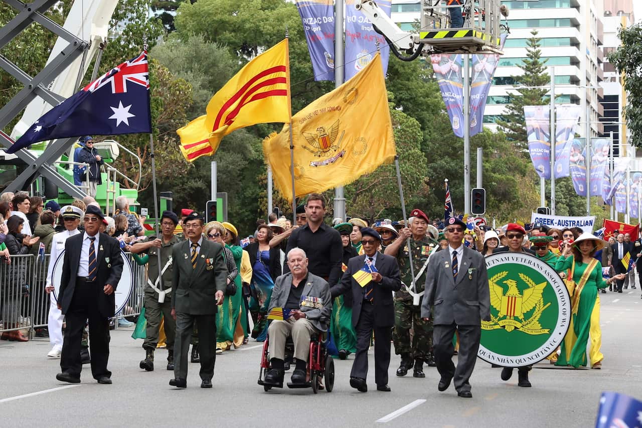 A group of men marching together on the road in commemoration of ANZAC day.