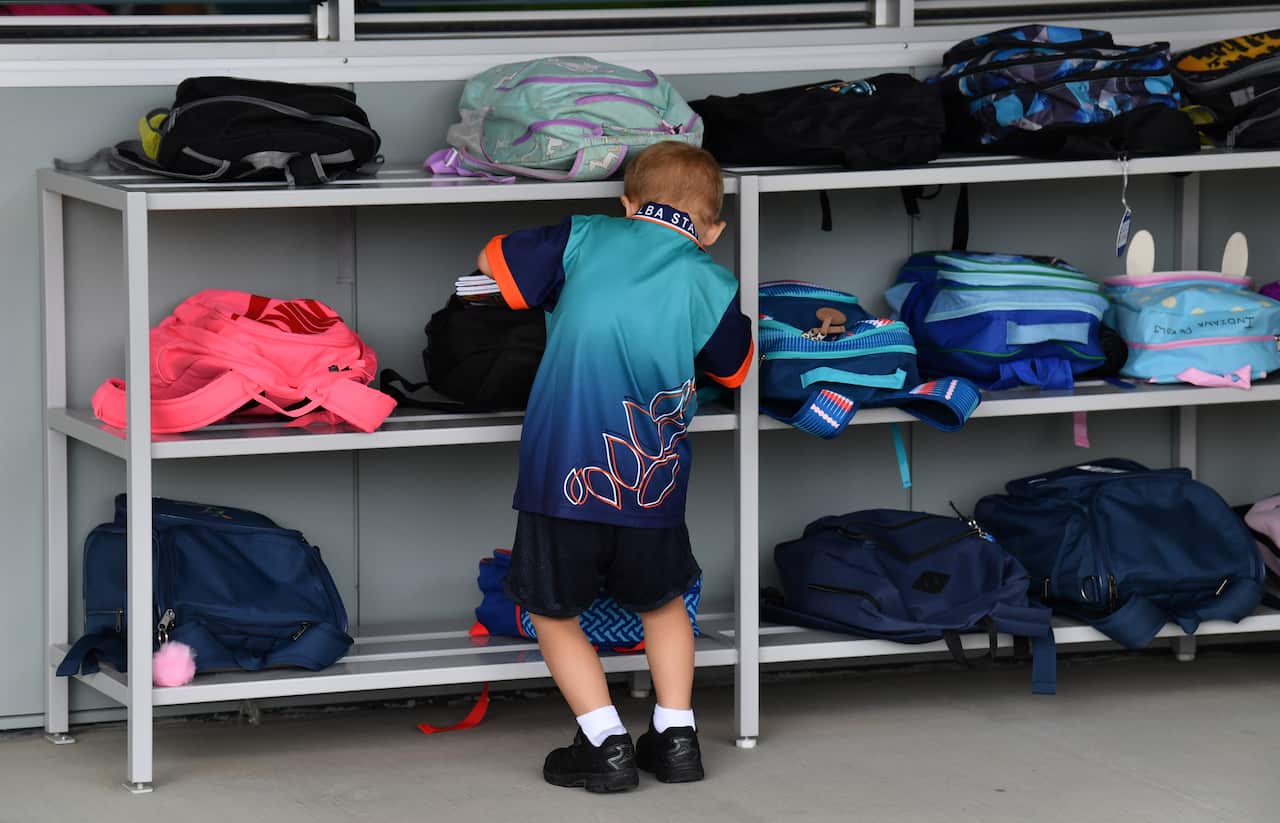 A young child looking through his schoolbag