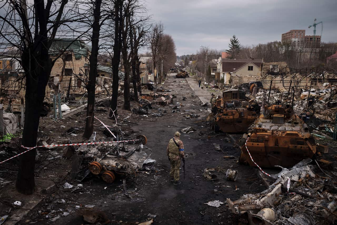 A Ukrainian serviceman walks amid destroyed Russian tanks in Bucha, on the outskirts of Kyiv.