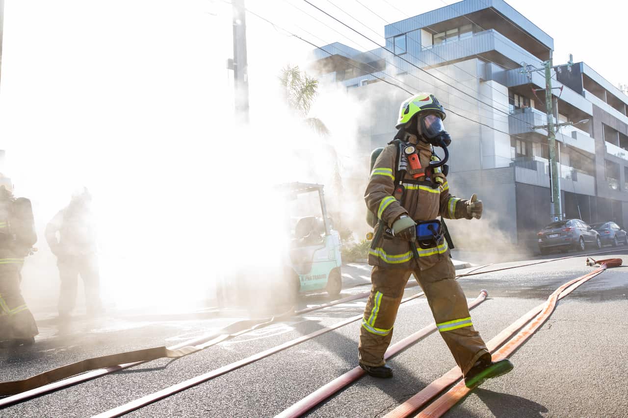 Firefighter wearing a gas mask as crews battle a factory fire.