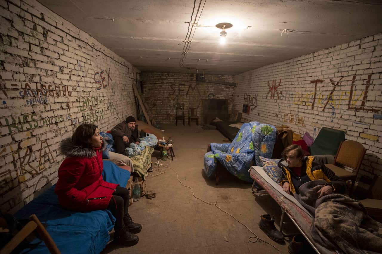 People take shelter in basements of their buildings damaged by bullets and cannonballs at Schastia town of Luhansk on February 22, 2022. 