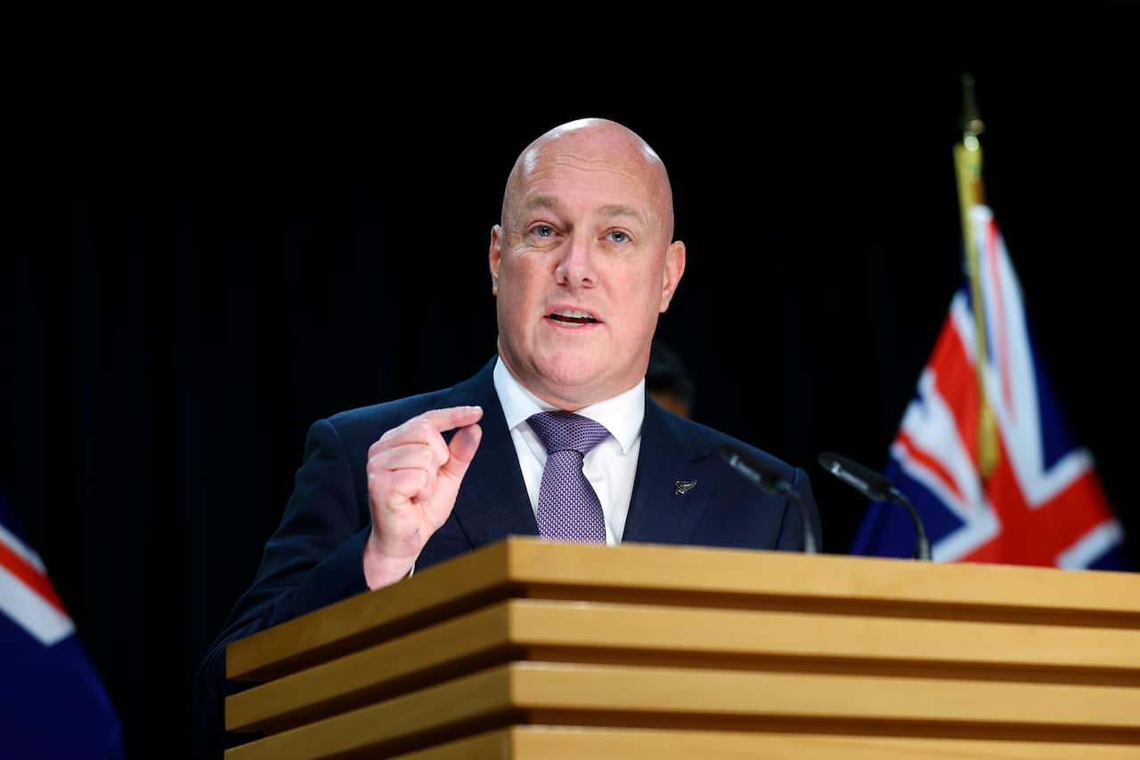 New Zealand Prime Minister Chris Luxon stands at a podium