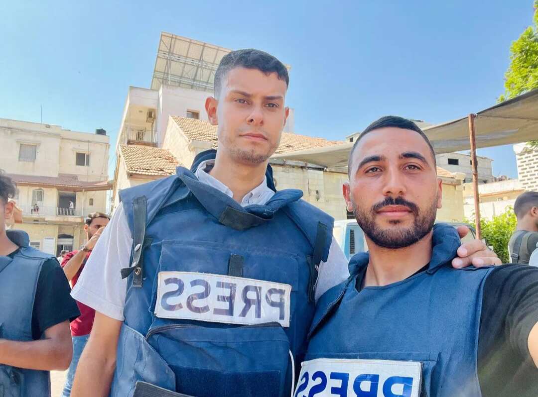 Two men wearing press gear