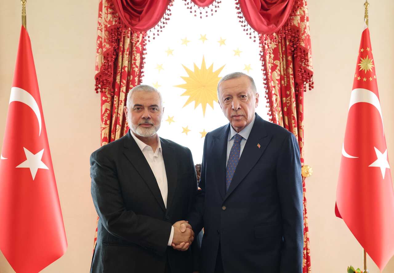 Ismail Haniyeh shaking hands with Recep Tayyip Erdoğan. The Turkish flag can be seen behind them.