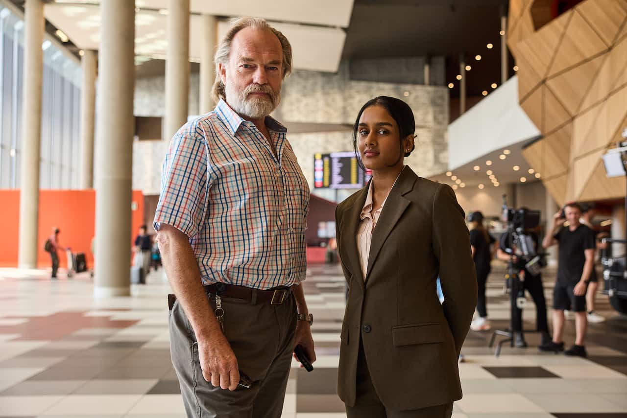 Hugo Weaving and Shabana Azeez during filming, with camera crew. 