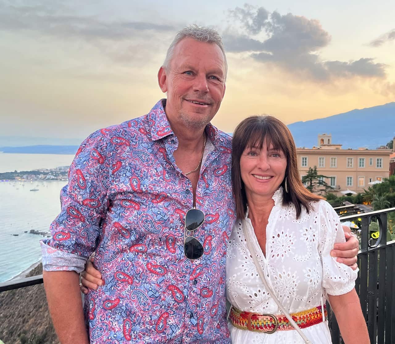 Kevin Packham and his wife, Jo standing against a rail with the sea in the background