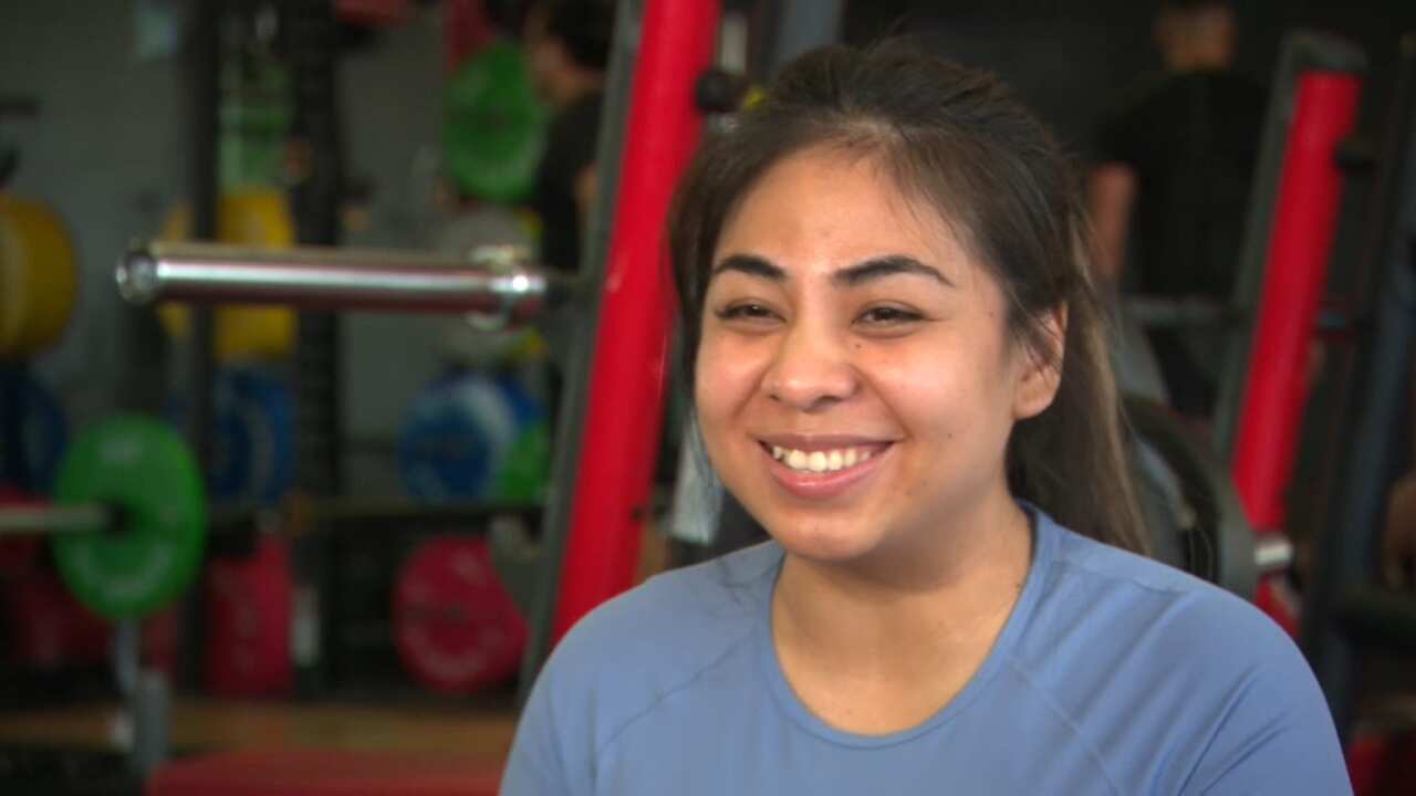 A woman in a blue shirt smiling at the camera.
