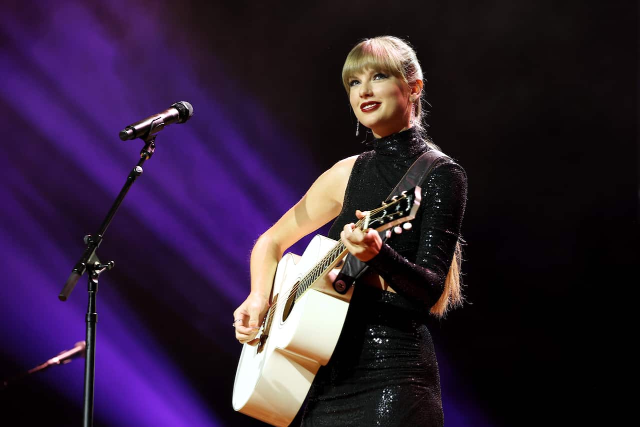 Taylor Swift on stage with a guitar