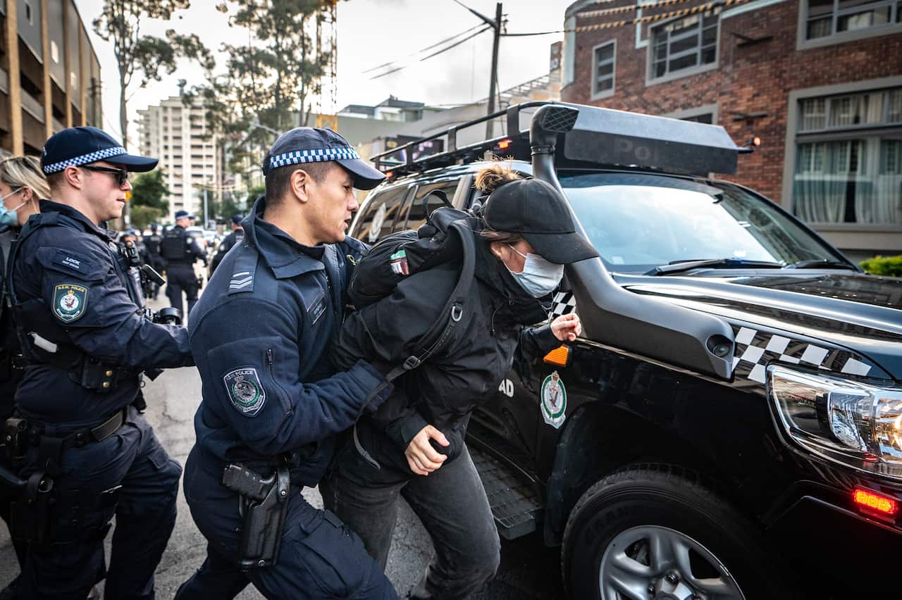 A police officer detaining a protester.
