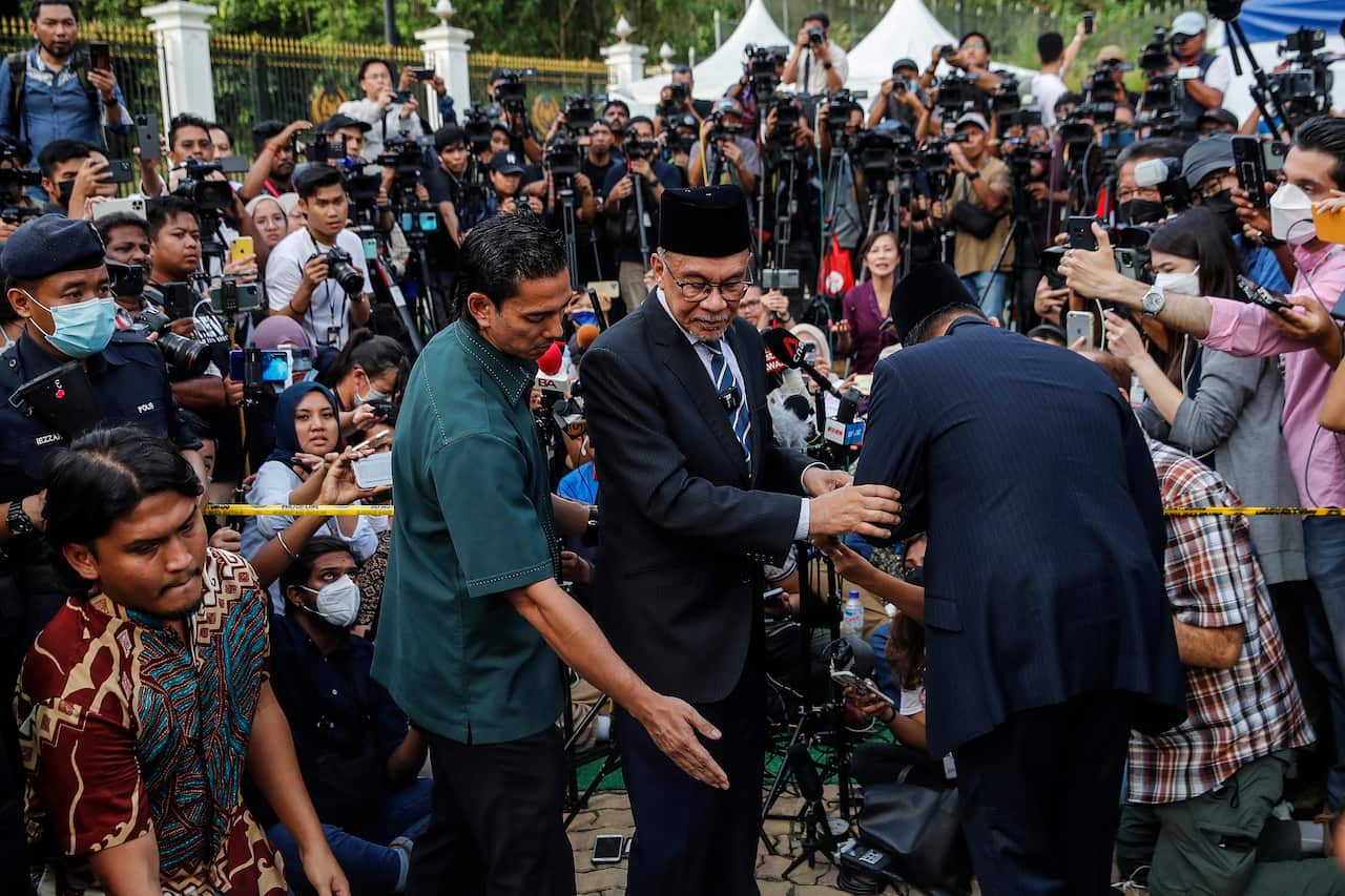 Anwar Ibrahim (centre) leaves the press conference at the entrance of the Istana Negara (National Palace) in Kuala Lumpur on 22 November 2022. 