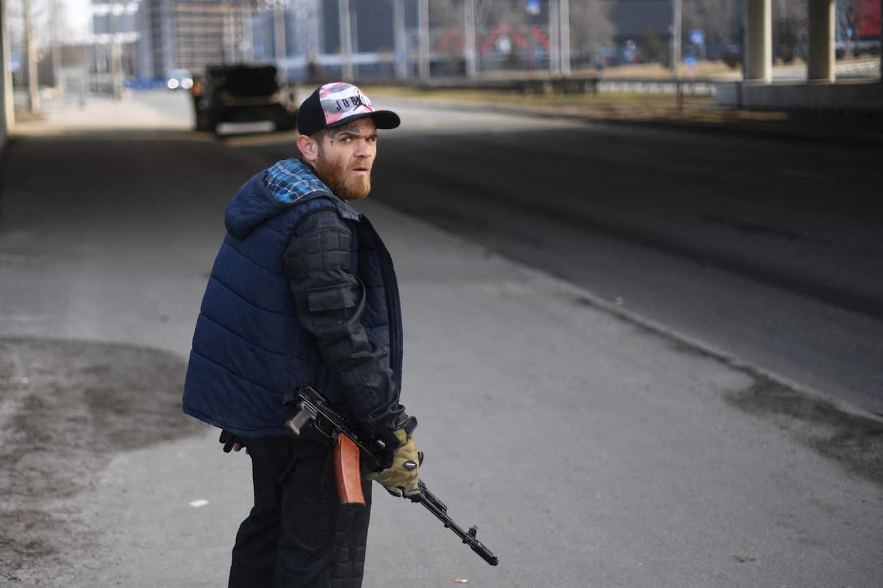  A volunteer, holding a rifle, protects a main road leading into Kyiv 