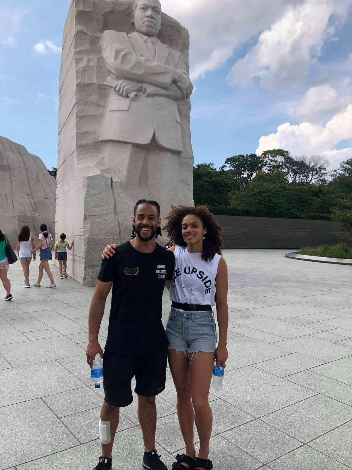 A couple pose in front of a stone figure of Martin Luther King Jr.
