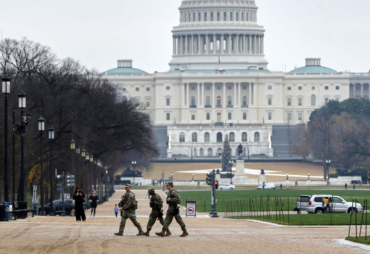 National guard troops in uniform patrolling near the White House building.
