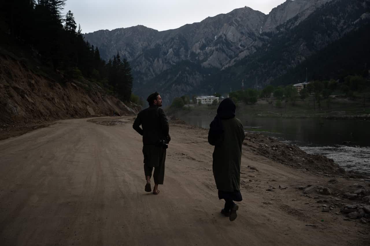 Two people walking on a road.