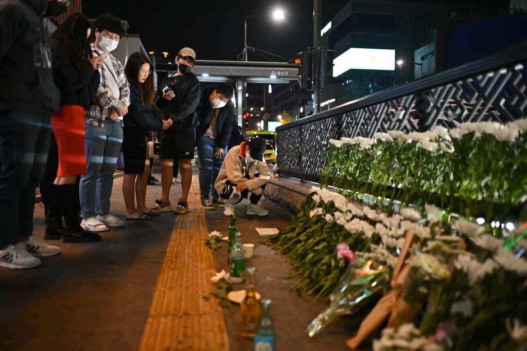 People look at tributes at a makeshift memorial outside the Itaewon subway station in the district of Itaewon in Seoul.