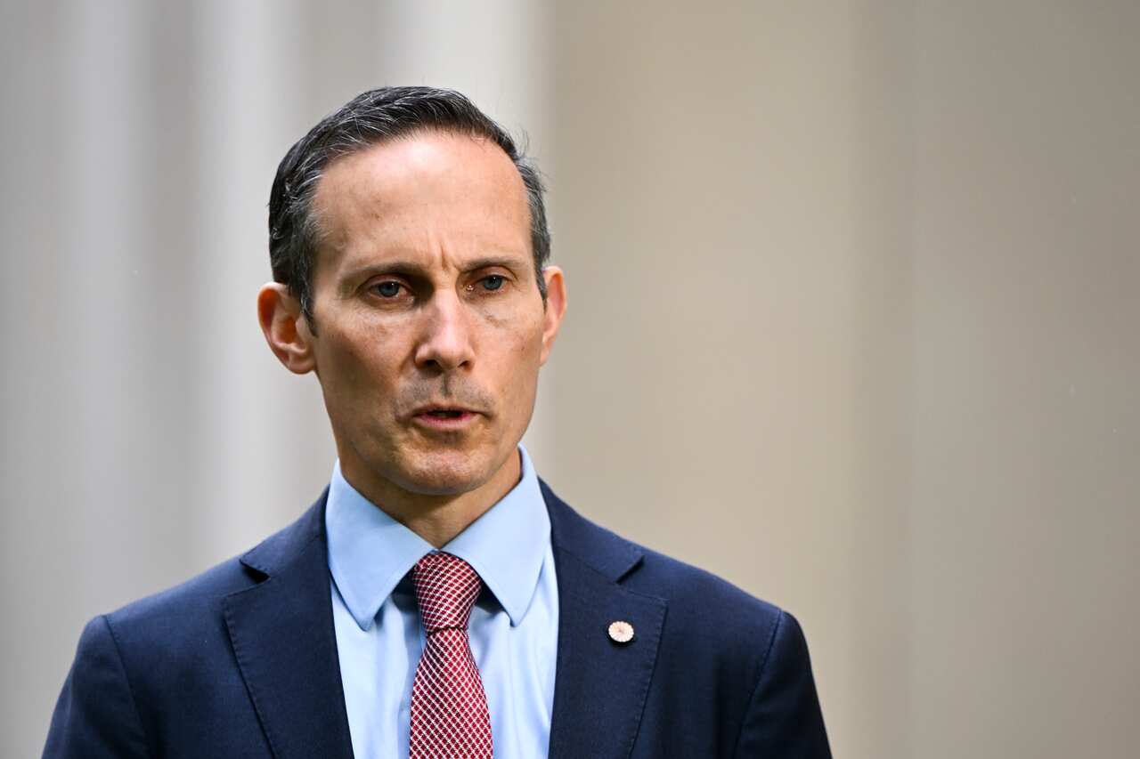 A man wearing a suit and tie who is speaking.