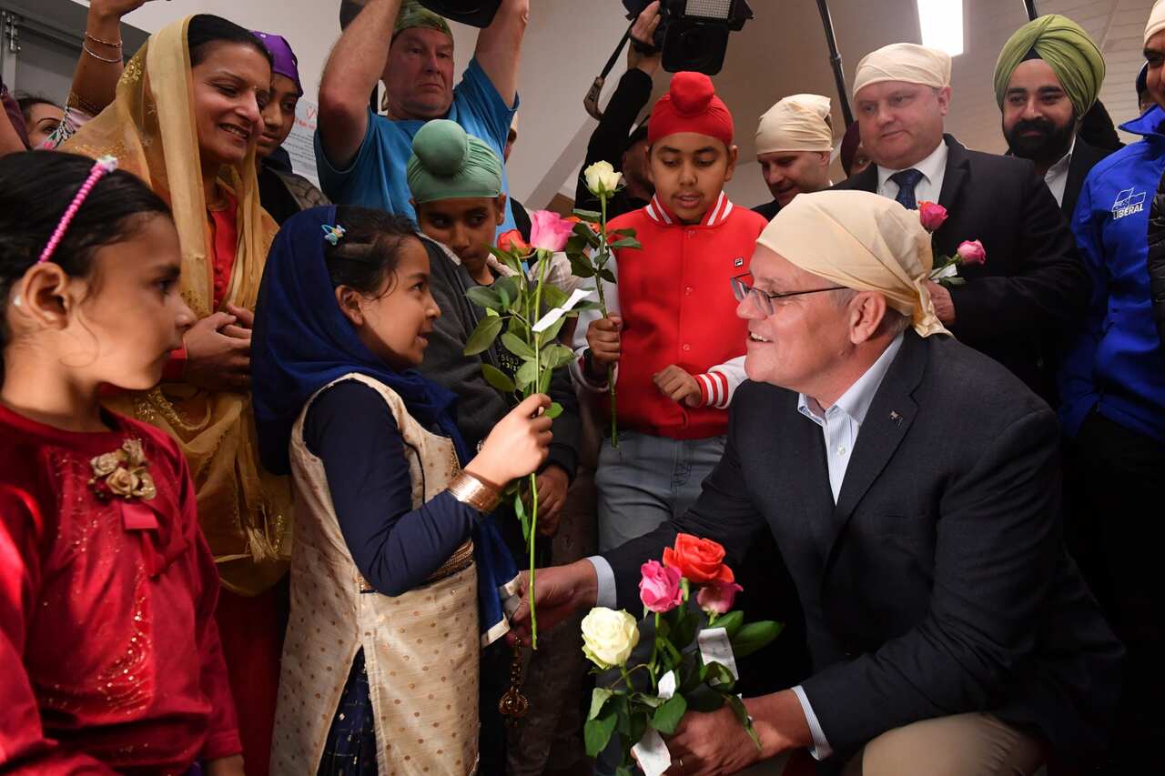 Prime Minister Scott Morrison receives flowers at a Gurdwara Siri Guru Nanak Darbar Sikh Temple in Pakenham in Melbourne on 14 May 2022. 