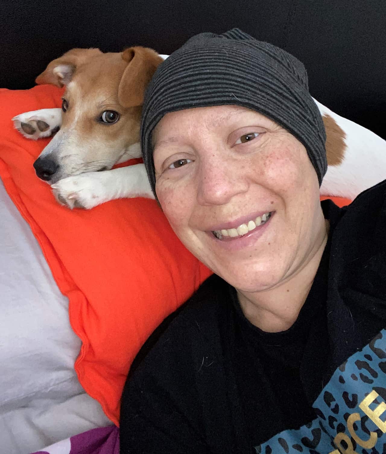 Macarena Erbs. She is lying on a pillow. A small dog is behind her on the pillow. 