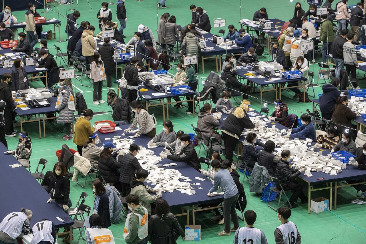 Workers are seen counting ballots at a ballot counting centre in Seoul, South Korea.